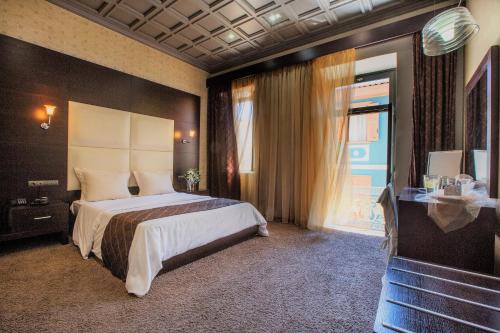 纳夫普利翁Aion Luxury Hotel的一间卧室设有一张大床和一个窗户。