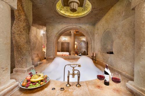 于尔居普Kayata Cave Suites Special Class的一间备有一碗水果的房间的浴缸