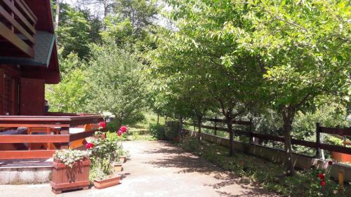 科拉欣Crkvine Chalet的一条有鲜花和树木的围栏旁的小径