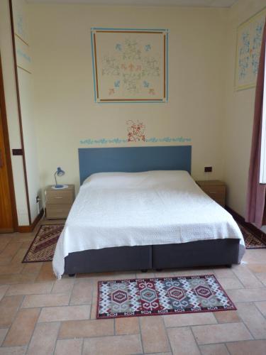 代森扎诺-德尔加达Appartamento palazzo del Provveditore vista lago的卧室配有一张床,地板上铺有地毯