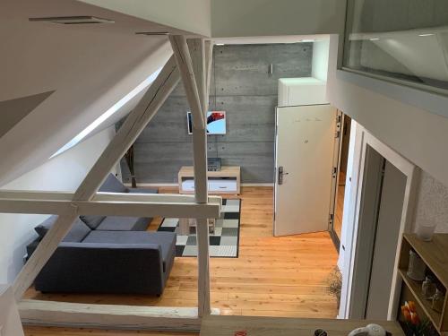 奥西耶克Loft Osijek的客房设有带沙发和冰箱的楼梯。