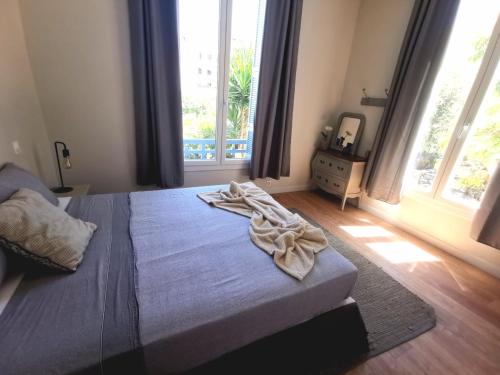 尼斯Appartement, 3 pièces, Villa Monte Europa的一间卧室配有一张床,床上有毛巾