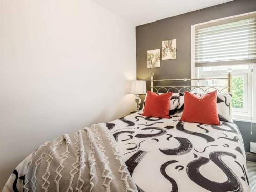 林肯Stylish Uphill Townhouse的卧室配有黑色和白色的床和红色枕头