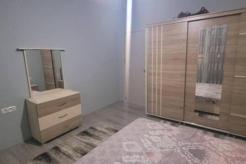 斯科普里Lovely 2-bedroom apartment的一间卧室设有梳妆台和大型木制橱柜。
