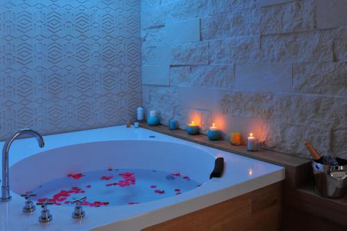 奥特朗托BluOtranto的浴室设有装有红色鲜花的浴缸。