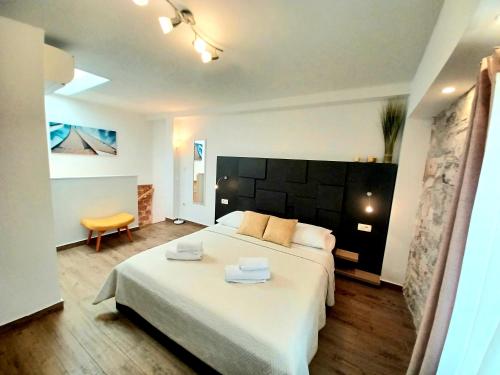 斯普利特Studio Apartmani Pomalo/ Take It Easy的一间卧室配有一张大床和两条毛巾