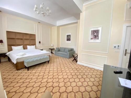 布加勒斯特Venetian Bucharest的一间卧室配有一张床、一张沙发和一个吊灯。