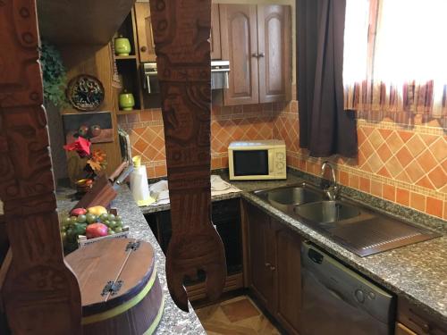 斯坎迪奇Casa Vacanze Neri的厨房配有水槽,柜台上放着一碗水果