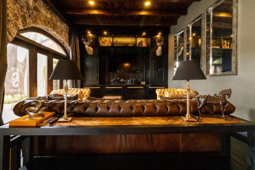 克雷塔罗Hacienda El Salitre Hotel & Spa的客厅设有真皮沙发和酒吧。