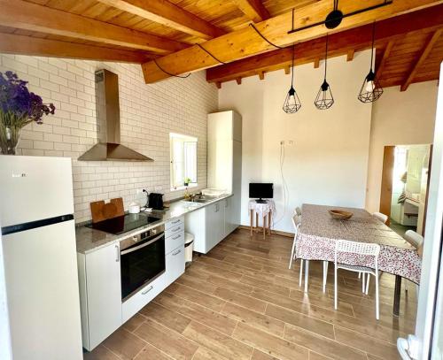 圣地亚哥-杜卡森Monte Vale das Éguas的一间厨房,配有白色家电和桌椅