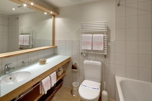 翁根Hotel Alpenrose Wengen - bringing together tradition and modern comfort的浴室配有卫生间、盥洗盆和浴缸。