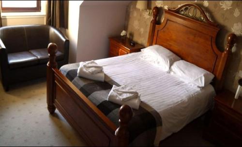 CairnessBan-Car Hotel的一间卧室配有一张木床和一把椅子
