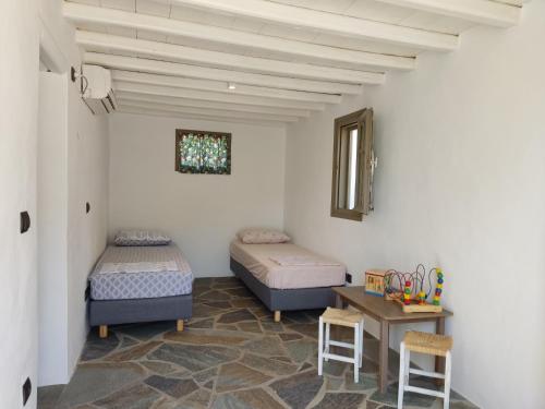 普拉提伊亚洛斯西弗诺斯Melia Sifnos House的配有两张床铺的客房配有桌椅