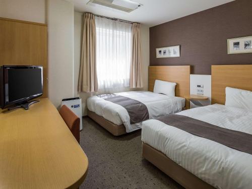 天童市天童康福特茵酒店的酒店客房设有两张床和一台平面电视。