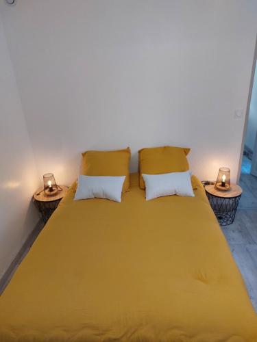阿格德appartement T2 AGDE centre à 10 mn des plages的一间卧室配有一张大黄床和两张边桌