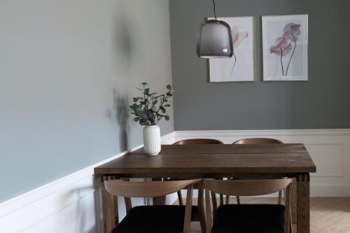 斯卡恩Ankerhus Skagen的餐桌、椅子和花瓶