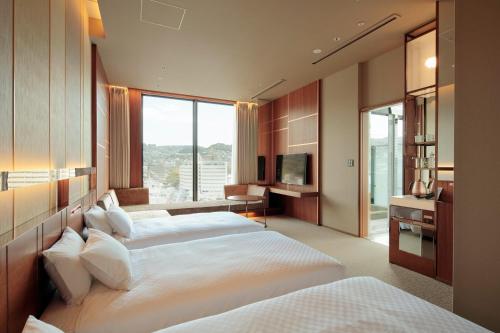 长崎Candeo Hotels Nagasaki Shinchi Chinatown的酒店客房设有两张床和电视。