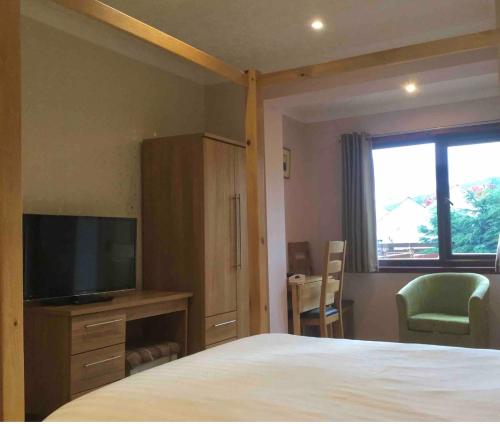 阿勒浦Island View House的一间卧室设有一张床、一台电视和一个窗口。