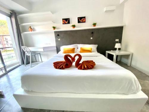 班拉克海滩STUDIO DESIGN 5 ETOILES Resort的一间卧室配有一张大白色床,上面有两颗心