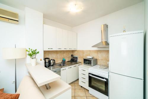 杜布罗夫尼克杜布罗夫尼克中心下城公寓 的厨房配有白色橱柜和白色冰箱。