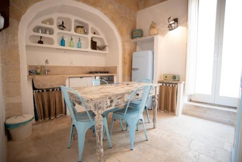 滨海波利尼亚诺Mareluna的厨房配有桌子和蓝色的椅子
