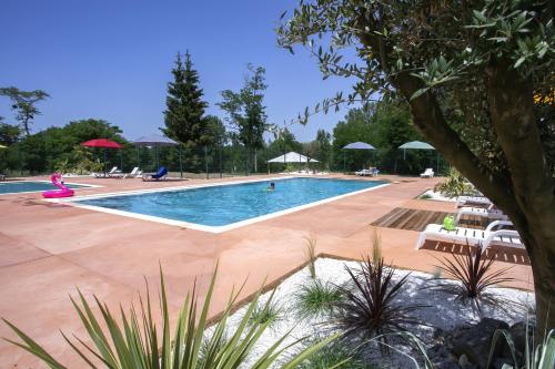 马泽尔拉巴斯蒂德度假酒店的一个带椅子和遮阳伞的大型游泳池
