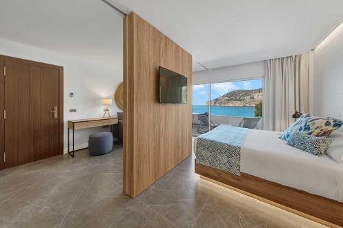 坎普德玛Bahía Suites Camp de Mar的酒店客房设有一张床,享有海景。