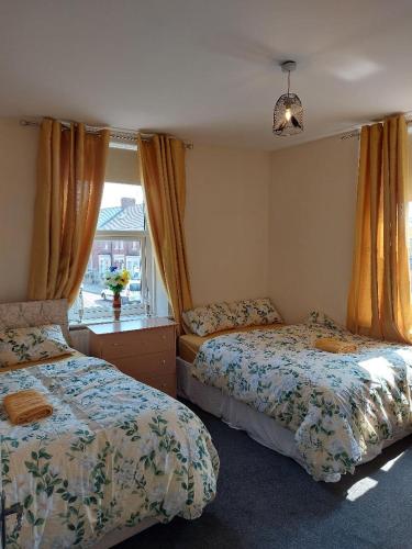 Hebburn-on-TyneThe Cosy 2 bedroom flat, sleeps 6的一间卧室设有两张床和窗户。