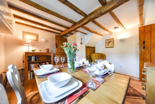 奥尔弗里顿Old Horns Cottage, Higham Derbyshire的一间用餐室,配有一张带白色菜肴的木桌