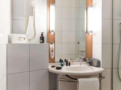 锡永Ibis Sion的白色的浴室设有水槽和镜子