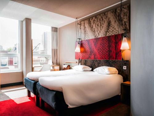 海牙海牙市中心宜必思酒店的酒店客房,设有两张床,铺有红地毯。