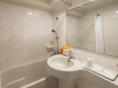 铃鹿市铃鹿酒店的浴室配有水槽和带镜子的浴缸
