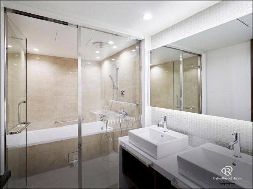 仙台Daiwa Roynet Hotel Sendai Nishiguchi PREMIER的浴室配有水槽、淋浴和浴缸。