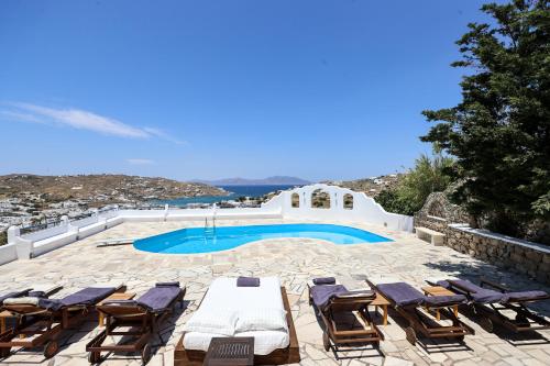 米克诺斯城Mykonos in White的一个带椅子的庭院和一个游泳池