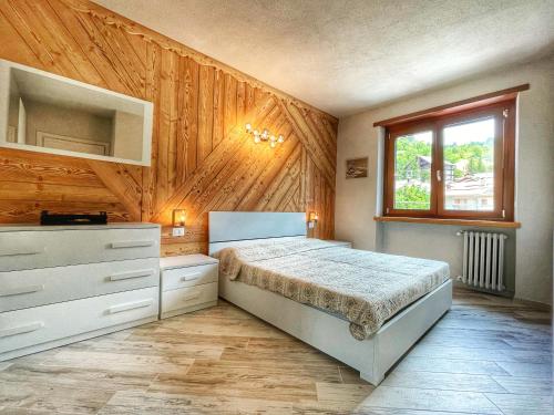 切萨纳·都灵尼斯Il nido dello Chaberton的一间卧室设有一张床和木墙