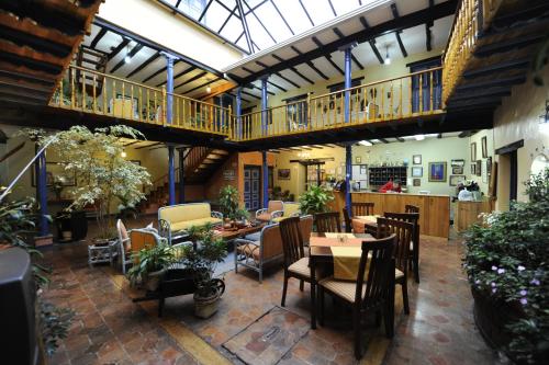 昆卡Hotel Posada del Angel的一间带桌椅的餐厅以及一个阳台