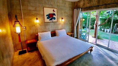 三百岭Namaste resort的一间卧室设有一张大床和一个大窗户