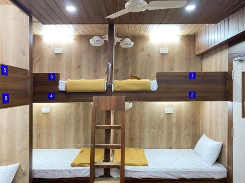 马尔冈City Stay AC Deluxe Hostel的带梯子的客房内的两张双层床