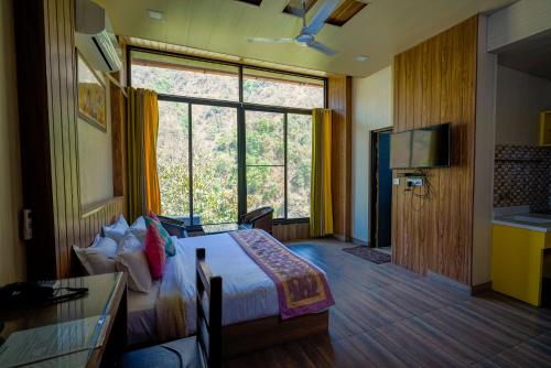 德拉敦Haut Monde Hill Stream Resort and Spa的酒店客房设有一张床和一个大窗户