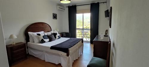 吉尔斯Residencial Do Rita em Rio Caldo的一间卧室设有一张大床和一个窗户。