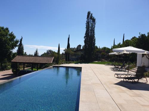 Talaveruela拉里斯亚酒店的一个带椅子和遮阳伞的大型游泳池