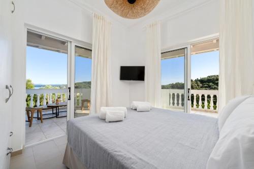 PetritíPlayia Villas III的白色卧室设有一张大床和一个阳台