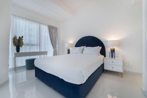 迪拜Blue dream apartment with Harbour view in Dubai Marina的白色的卧室设有一张大床和一个窗户