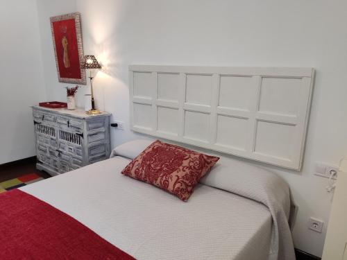 塞尔塞迪利亚EL MOTIVO的一间卧室配有一张红色枕头的床