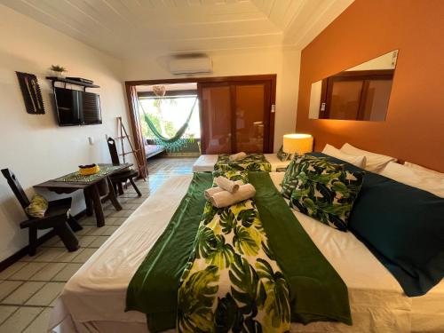 布希奥斯Casa de CINEMA 3 suites, 50m da Praia da Ferradura的一间卧室配有两张带绿色和白色毯子的床