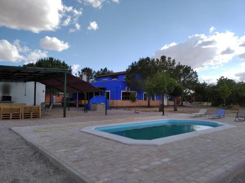 巴尔德佩尼亚斯La Venta de las Estrellas Casas Rurales的一座位于庭院的小游泳池,庭院内有一座建筑