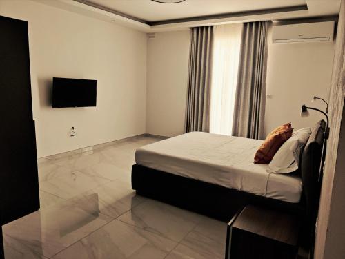 马尔萨斯卡拉SouthShore Accommodation的卧室配有一张床,墙上配有电视。