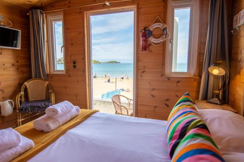 纽基Tolcarne Beach Cabins的一间卧室配有一张床,享有海滩美景