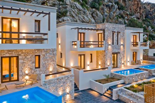 Kyra PanagiaYpsilos Beach Suites的两座游泳池前的别墅