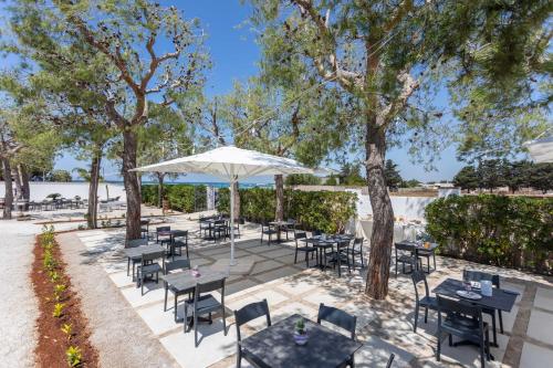 切萨雷奥港B&B Villa Massimo的一个带桌椅和遮阳伞的户外庭院